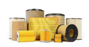 A variety of yellow and tan textured cylindrical and rectangular vehicle filters on a white background.